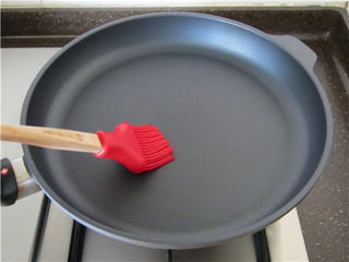 9、杂粮煎饼果子,平底锅上火，中小火加热，感觉锅底略热时（不可太热），用小刷子均匀刷上一层油脂