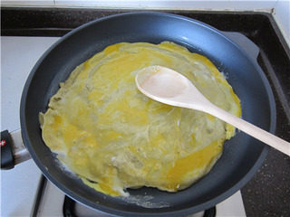 11、杂粮煎饼果子,保持中小火，在面皮上打入一个鸡蛋，摊平摊薄