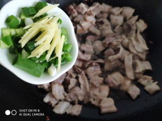 9、家常五花肉炒土豆,加入切好的葱姜炒香。