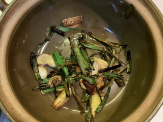 10、葱油焖鸡,准备好砂锅,把炒香的葱姜蒜捞出来,放入砂锅锅底,剩余的油留在平底锅里