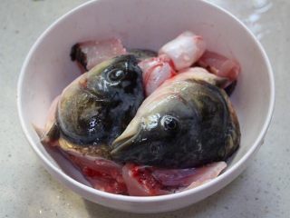 1、水煮鱼片这么烧,健康营养有颜值!全家人吃了赞不绝口!,草鱼去头,切两半,片去鱼骨,鱼肉切成薄片,这个过程太血腥,不放图,可以在买鱼的时候让商家帮忙切好,鱼头,鱼骨用料酒和少许盐腌制入味