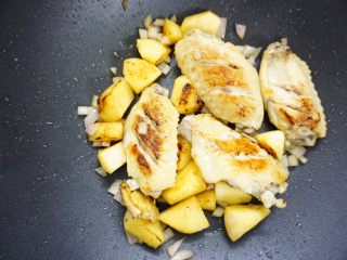 7、鹰嘴豆焖鸡翅,苹果和鸡翅都煎好后，放入洋葱丁爆香。