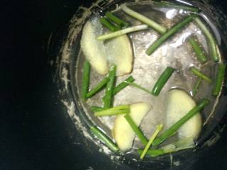 4、电饭煲豉油鸡,电饭煲加油烧热把葱段和姜片放入爆香