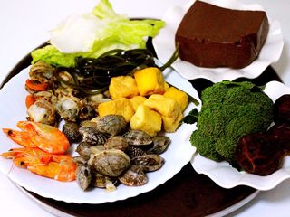 1、麻辣海鲜什锦营养火锅????,花蛤提前用盐水浸泡吐沙、海虾洗净后煮熟、扇贝洗净后煮熟、把其它所有食材都摘洗干净后备用……