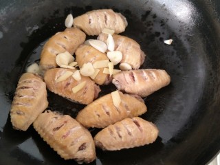 8、可乐鸡翅,然后放入葱段，姜片蒜片继续煸炒。