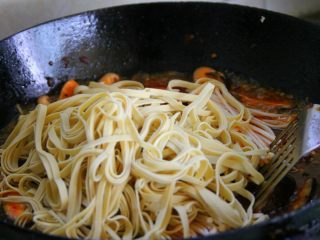 18、香辣烤鱼,放入千张和金针菇，倒入水大火煮开，转小火煮至7成熟。