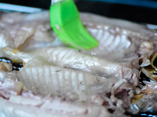 8、烤鱼,10分钟后，取出鱼，刷一层油。