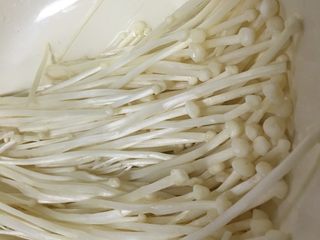 1、培根卷金针菇,将金针菇切去老根，摘洗干净控水