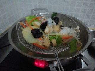 12、东北双人份麻辣拌之酸甜拌,水开后放入其他蔬菜还有小香肠和豚骨拉面里面的那片薄薄的豚骨，大火煮五分钟，稍微翻拌一下，总之煮熟就可以，可以捞个菜尝尝。然后用漏勺捞起来，空干水分，尽量不要水，放入一个特别大的大碗或者盆里面。