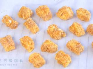 3、炸牛奶,奶块码放在放了油纸的烤盘上，烤箱预热180度。