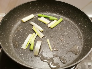 6、冬至美食 红烧肉卤蛋,煎锅中加入食用油 放入葱段 炒香