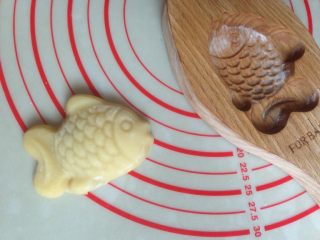 10、小鱼儿蔓越莓绿豆月饼,将模具倒扣，在桌面上敲一下，整个月饼坯敲出