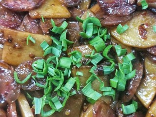 18、酱香土豆炒腊肠,撒蒜苗叶，关火。