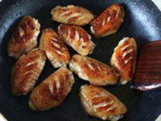 4、自制【翅中虾火锅】,锅里留一点底油，放入腌好的 鸡翅小火慢慢煎至两面焦黄，盛出备用。