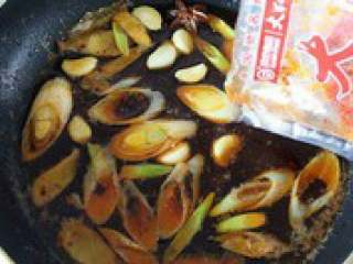 6、自制【翅中虾火锅】,放入大红袍（其他麻辣火锅料 也可以）火锅料，炒出红油，爆 出麻辣香味。