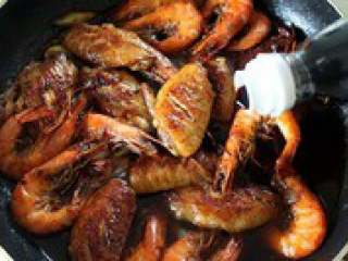 8、自制【翅中虾火锅】,倒入煎好的鸡翅，翻炒2分钟使 鸡翅吸收香辣味，倒入盐，酱油 再翻炒几下。