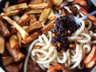 9、自制【翅中虾火锅】,倒入土豆粉，炸红薯条，老干妈，继续翻炒2-3分钟。