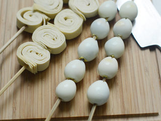 2、家常麻辣烫,将豆皮卷好切开，和鹌鹑蛋串到竹签上