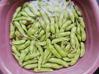 2、水煮毛豆,放入盆里,用大量清水浸泡