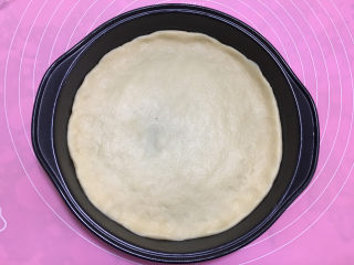 13、美味的牛排披萨,用手将饼皮压成和披萨盘一样大小圆形。