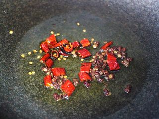 12、孜然老醋辣爆鸡胗,锅烧热后倒入花生油烧至六成热时，先爆香花椒和干辣椒。