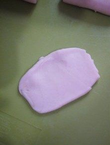 6、黑芝麻酥皮月饼,取一只卷好的剂子,按扁擀开,中间略厚四周薄。