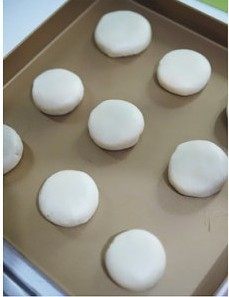 8、黑芝麻酥皮月饼,利用左手虎口处慢慢将皮向上收紧,口收好后,去除多余面团,整理成圆形,收口朝下稍按压成型