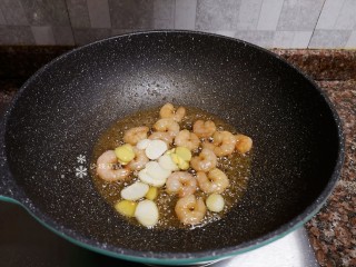 8、莴笋炒虾仁,放入生姜和大蒜片翻炒出香味。