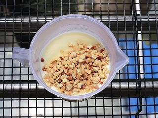 12、奶香浓郁哒-花生小奶糕,一切准备好后，将花生碎倒入冷却的雪糕液中，切不可提前，早放会变软，极其影响口感