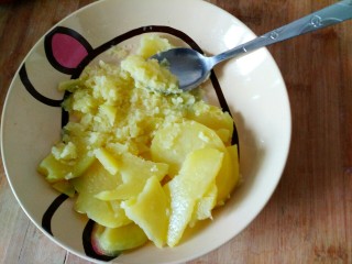 5、#圆土豆#黑芝麻土豆球,土豆片放入盘里，放入两小勺白糖，用勺子压层土豆泥