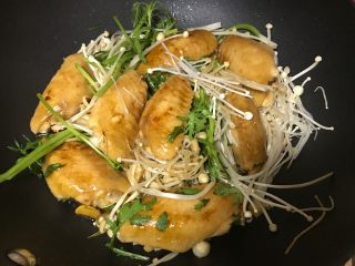 9、金针菇鸡翅煲,将洗净的金针菇放入锅底（我还放了些茼蒿），然后再放上鸡翅。