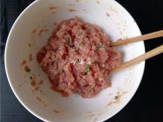 3、四川抄手,肉馅用筷子往一个方向搅拌至肉馅起胶;再调入葱末,再搅拌均匀;