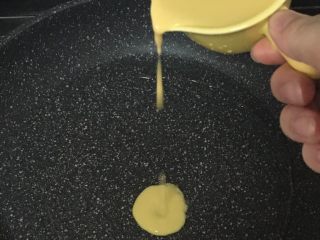 7、宝宝辅食之小米软饼,热锅刷油，开小火，用勺子舀一勺面糊从上往下倒入锅里，自动形成圆形。煎至金黄色后翻面继续煎至金黄色就可以了。