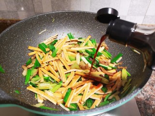 11、蒜苗炒香干,倒入适量生抽翻炒均匀。