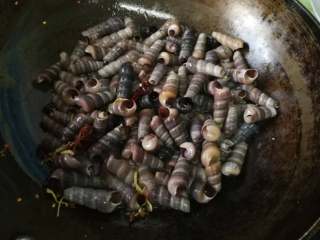 8、酱爆香辣钉螺,放入提前洗好控干水的钉螺。加入料酒炒2分钟左右。