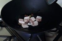 3、农家铁锅鱼,放入五花肉片煸炒变色后再放入八角煸炒