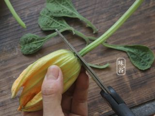 3、酥炸南瓜花,把梗部剪去；