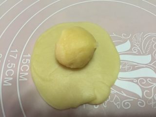 10、香蕉酥,取一份水油皮用手按扁后擀成圆形，包入一块油酥