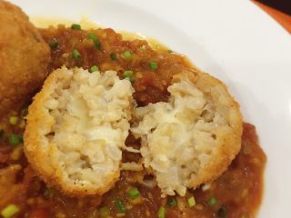 13、炸起司飯糰佐鮮蕃茄醬汁,盤裡放入鮮蕃茄醬汁再擺上炸飯糰,用蔥花或巴西里葉或羅勒做裝飾。趁熱吃,起司會拉絲喔~