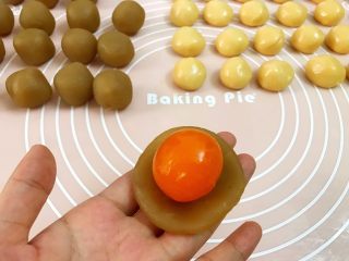 2、广式低糖莲蓉蛋黄月饼,取一份莲蓉馅压扁，放入一整个蛋黄