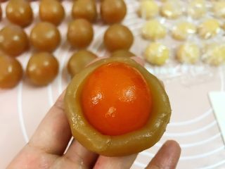 3、广式低糖莲蓉蛋黄月饼,用虎口慢慢往上推（没有烤过的蛋黄更紧贴教莲蓉馅）