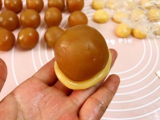 5、广式低糖莲蓉蛋黄月饼,取一份饼皮稍稍压扁，一手托住饼底，一手用虎口慢慢往上推（很多朋友不会推皮，就把饼皮擀成很大一块去包，我不建议这样做因为会有空气进入，导致烤好的月饼鼓包不好看）
