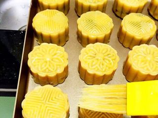 11、广式低糖莲蓉蛋黄月饼,一个蛋黄加入少许清水调匀。用羊毛刷蘸取蛋黄水在碗边微微逼出，再刷月饼表面，一定不能刷多，会导致月饼花纹不清晰。刷好蛋黄水后再放入烤箱180度烤15分钟即可