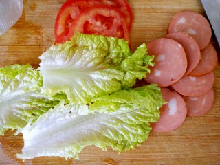 5、全麦土司三明治,趁煎蛋的时间准备火腿，西红柿，生菜，如图