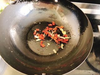 12、香甜辣味虾-年夜饭、宴请菜,把刚才炸虾的油倒去，留少许在锅中，开大火，倒入辣椒、香叶、花椒炒香。