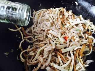 19、#绿色美食# 韭菜肉丝香干小炒,倒入1勺的料酒。