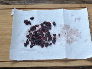 2、桂花蔓越莓松糕,蔓越莓干用温热的水泡半分钟至软，捞出用厨房纸巾吸干水分备用。