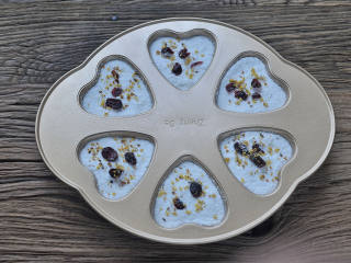 7、桂花蔓越莓松糕,再铺过筛好的粉至模具满，表面撒几颗蔓越莓干和一些干桂花。