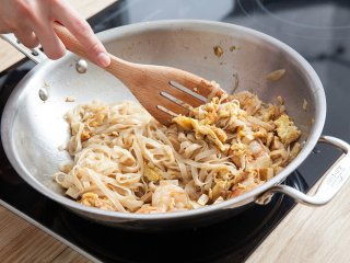 6、 泰式大虾炒粉,锅内放入米粉，加入酱料一同翻炒