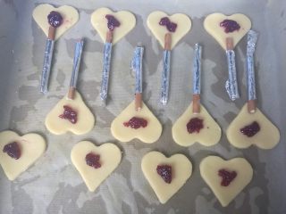 7、爱心夹心挞饼,烤箱上下火预热180度,排入烤盘,中间放上蓝莓酱,做好的百醇手柄放在底部中间位置,用手轻轻按压下。